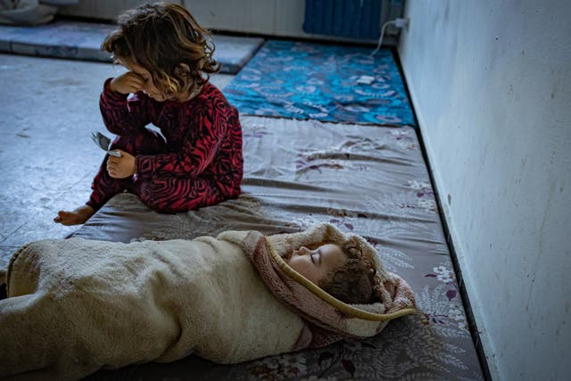 <p>Asmaa’s five-month-old baby swaddled in a blanket, with another of her children at a school in Tyre. The family is among those who have had to flee the clashes at the Lebanon-Israeli border</p>