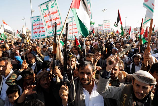 <p>People hold Palestinian flags during a protest against the recently announced operation to safeguard trade and to protect ships in the Red Sea, in Sana’a, Yemen, 22 December 2023</p>