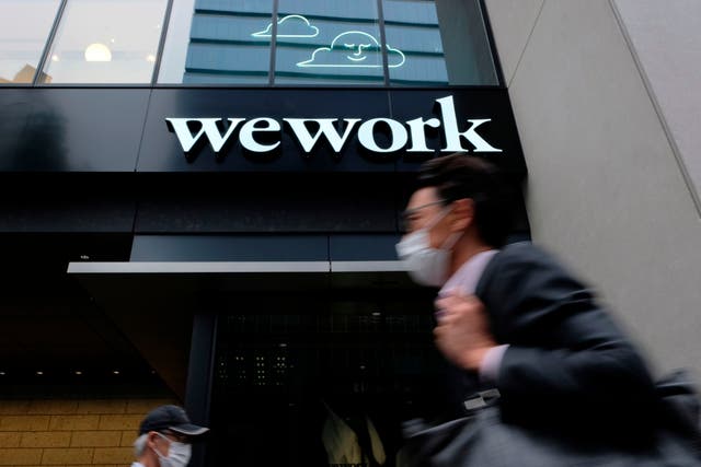 <p>File: A man walks past the logo of WeWork in Tokyo</p>