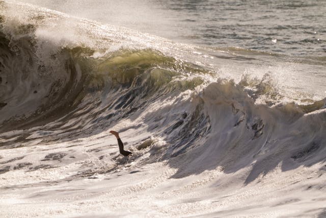 <p>A surfer goes under the waves in Seal Beach, Calif., Saturday, Dec. 30, 2023. </p>