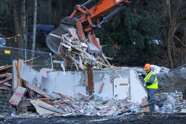 <p>A worker rakes debris during a pause in the use of heavy equipment to demolish the house where four University of Idaho were killed </p>