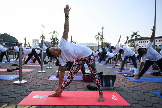 <p>Yoga enthusiasts perform yoga during an event to mark the International Day of Yoga at Malaysia’s Batu Caves temple, on the outskirts of Kuala Lumpur on June 21, 2023</p>