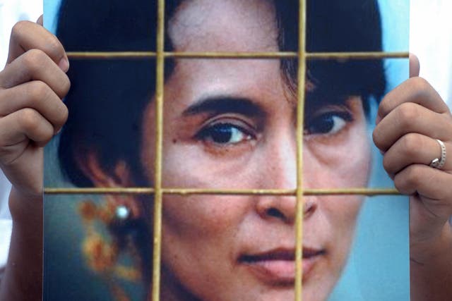 <p>A Myanmar activist holds a portrait of Aung San Suu Kyi during a protest at the Chinese embassy in Bangkok in August 2009</p>