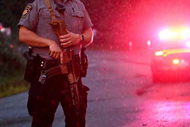 <p>Police with rifles monitor a wooded perimeter in the rain on day 10 of a manhunt for convicted murderer Danelo Cavalcante on September 9, 2023 in Kennett Square, Pennsylvania</p>